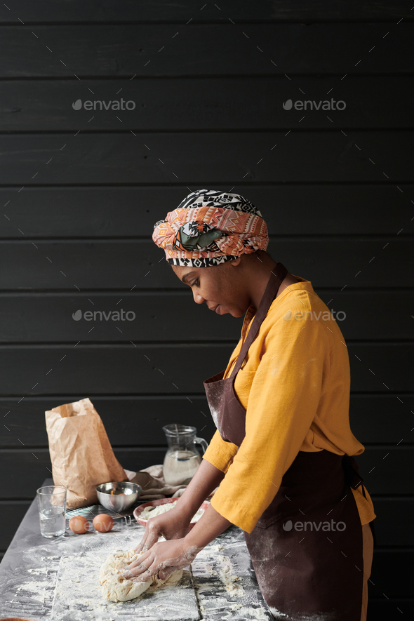 Woman using a dough cutter to divide the naan bread dough into six equal  portions which are flattened and baked. Bakers and pas Stock Photo - Alamy