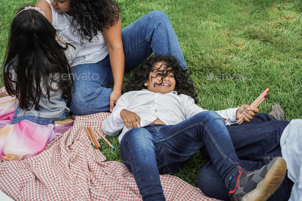 Happy indian family having fun at city park painting and laughing together - Stock Photo - Images