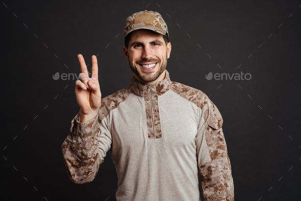 Happy masculine military man smiling and gesturing peace sign