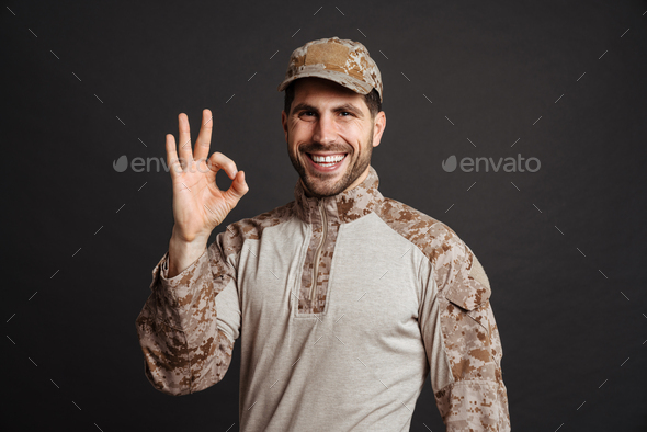 Happy masculine military man smiling and showing ok sign