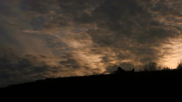 Pilot or Aviator Man Silhouette Plays Running Outdoor with His Carboard Airplane alt