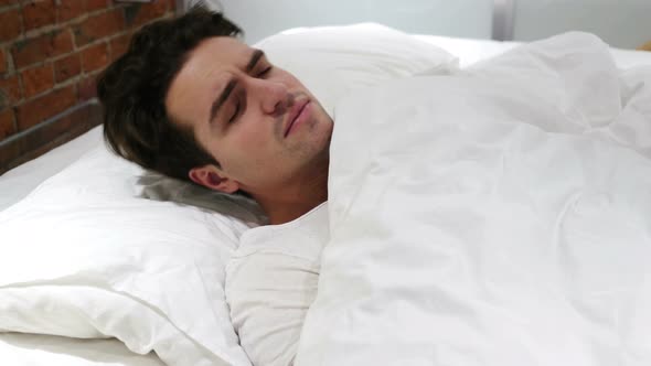 Uncomfortable Man Sleeping in Bed at Night, Restlessness alt