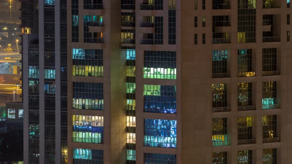 Windows of the Multistorey Building of Glass and Steel Lighting Inside and Moving People Within alt