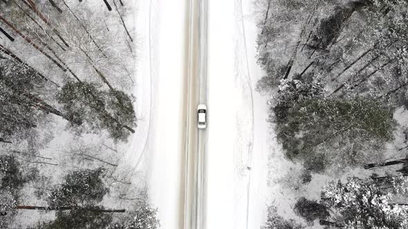 Classic Gray Car Driving Through the White Winter Snowy Forest on Country Road alt