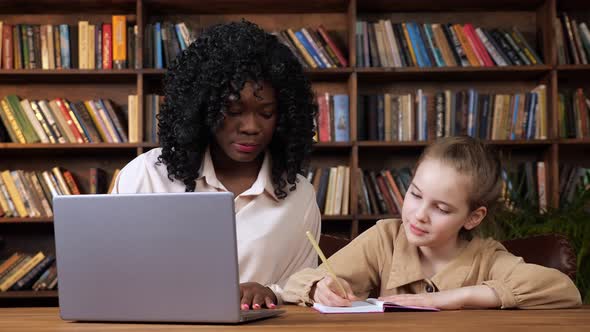 Individual Teacher Explains Student Material and Girl Writes alt