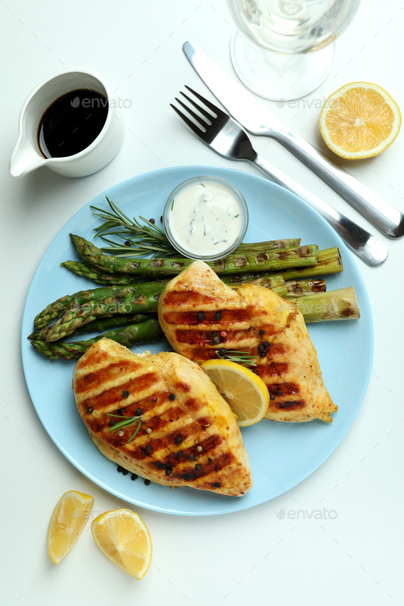 Concept of tasty lunch with grilled chicken and asparagus on white background
