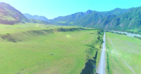 Aerial Rural Mountain Road and Meadow at Sunny Summer Morning. Asphalt Highway and River. alt