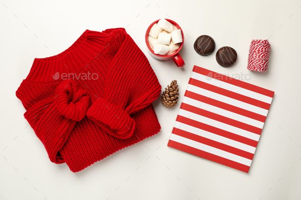 Sweater, cup of coffee with marshmallow, cone, copybook, biscuits and string on white background