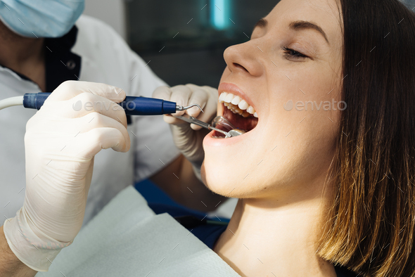 Dentist check patient cavity using instruments at clinic - Stock Photo - Images