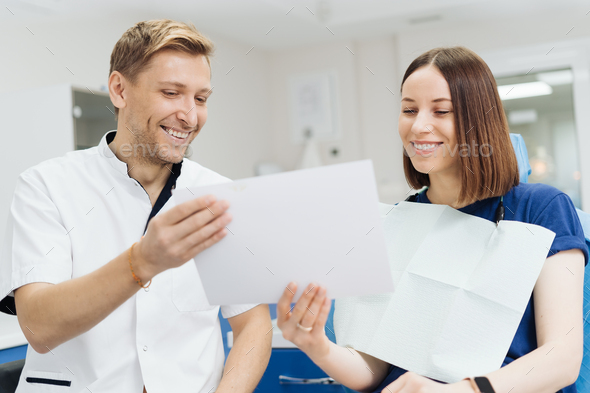 Dentist discussing with patient treatment plan - Stock Photo - Images