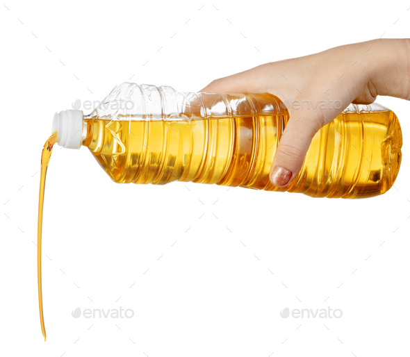 Hand of woman pouring cooking oil from plastic bottle. Isolated on