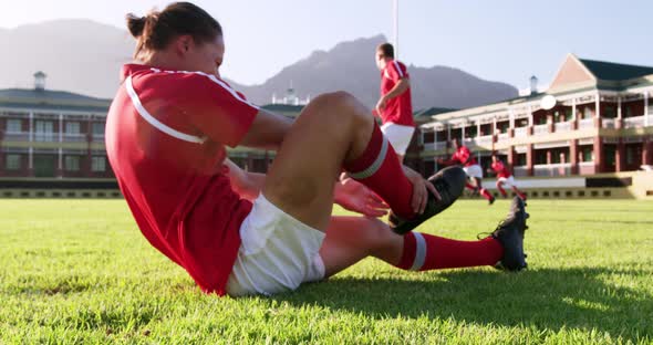 Male rugby player sitting on the ground in stadium 4k
