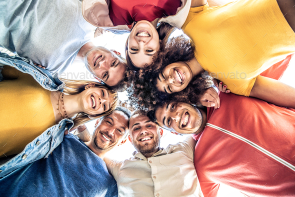 Multiracial group of young people standing in circle and smiling at camera - Stock Photo - Images