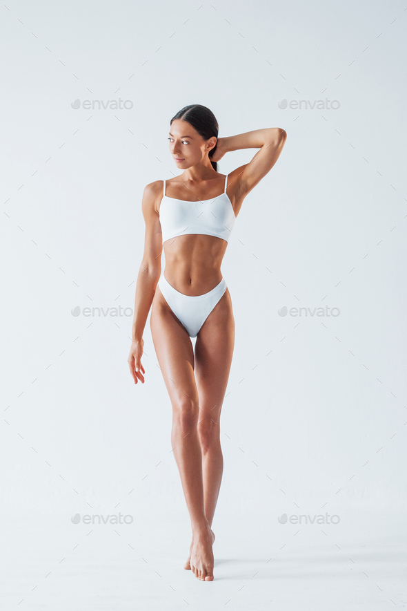 Sexy woman in black underwear sitting on the white chair in the studio  Stock Photo by mstandret