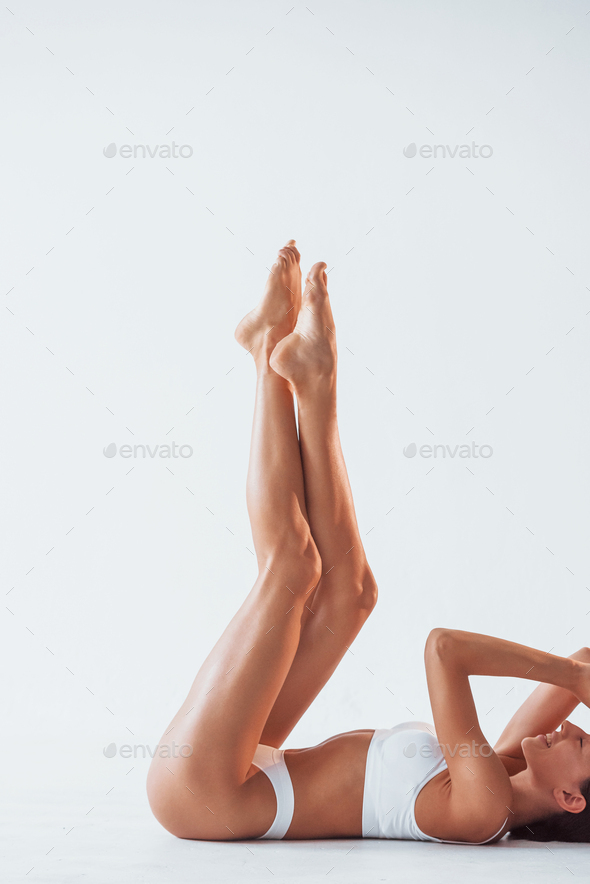 Side view of girl that lying down. Beautiful woman with slim body in  underwear is in the studio Stock Photo by mstandret