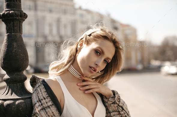 Close up portrait of pleasant looking female has no make up, holds hand  under chin, looks with charm Stock Photo by wayhomestudioo