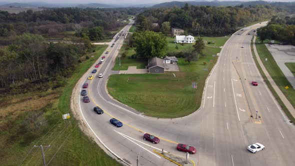 Aerial view of corvette car tour on rural road turning to highway in western Wisconsin.