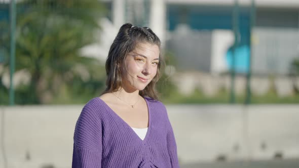 Close View of Darkhaired Girl with Lollipop Outdoors on Windy Day alt