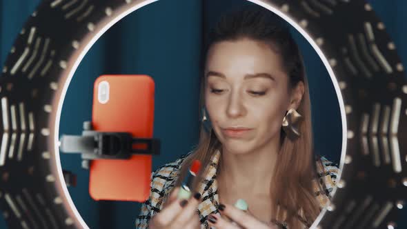 Female Beauty Blogger is Adding Blush on Cheeks Sitting in Front of Ring Light