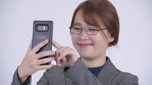 Face of Young Happy Asian Businesswoman Using Phone alt