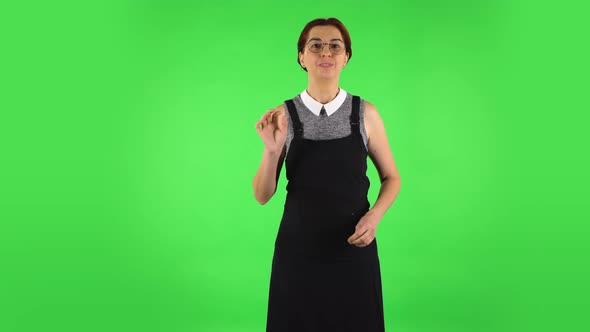 Funny Girl in Round Glasses Is Waving Hand and Showing Gesture Come Here, Green Screen alt