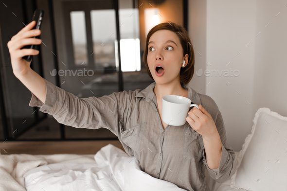 A Woman Sits On The Bed Beside A Face-down Man Coffee Mug by