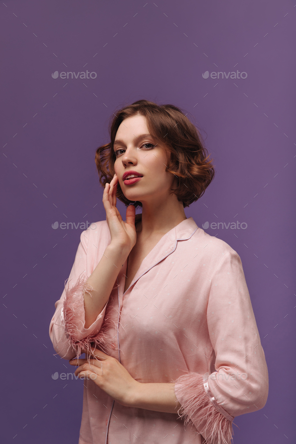Lounge and wellness concept. Portrait of charming young ginger-haired lady, wearing pink pajama wit