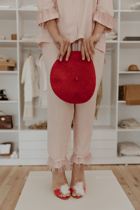 Thin lady in pink stylish polka dot pajamas and home red high heels