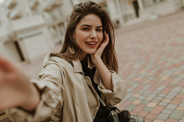 Beautiful young stylish brunette woman wearing midi green coat