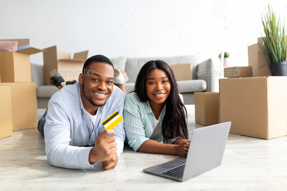 Shopping for household goods online concept. Happy black family buying stuff for their new house