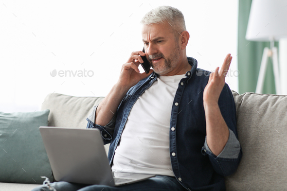 Angry mature man having phone fight with Internet provider
