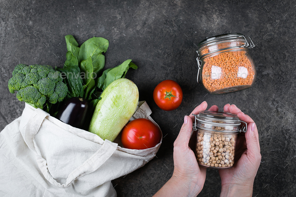 Woman holding jar of chickpeas. Vegetables in eco reusable bag. Eco friendly, zero waste concept.