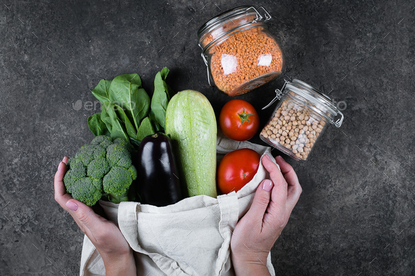Zero waste concept. Female hands holding vegan vegetables in coton reusable bag