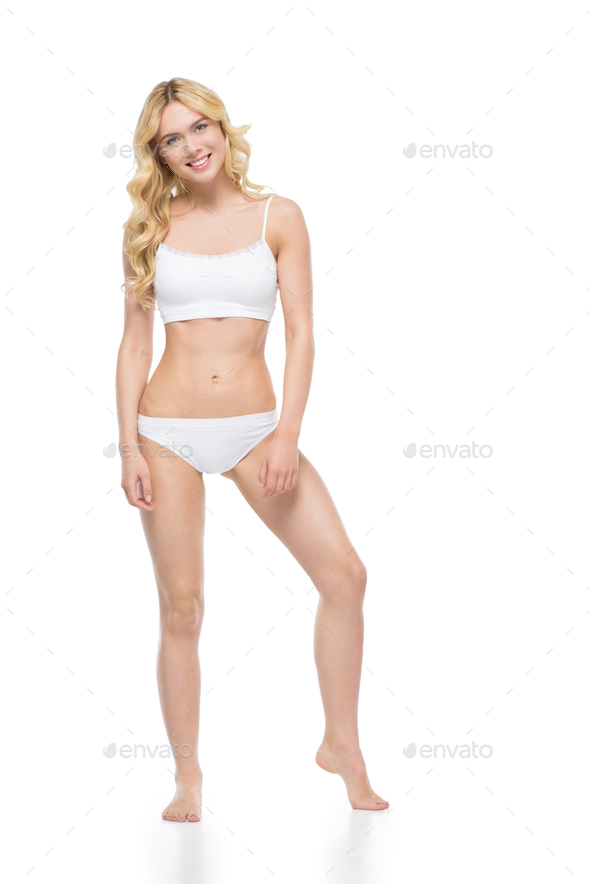 Young blonde woman posing in white underwear and smiling at camera