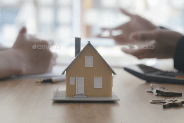 Close up house model on blur background of real estate agent and customer  Stock Photo by ijeab