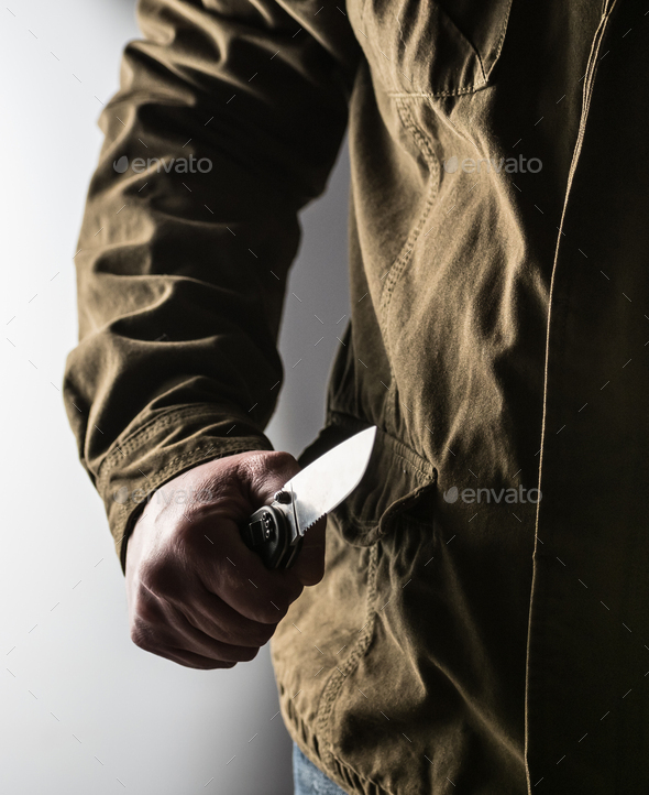 Man holding a knife in a threatening stance Stock Photo by alexbowmore