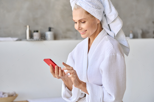 Portrait of smiling senior lady woman looking at cellphone using beauty app.