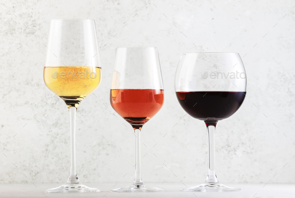 Wines assortment. Red, white, rose wine in wineglasses on gray background.  Stock Photo by 5PH