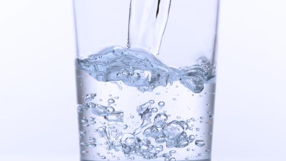 980034Water being poured into Glass against White Background, Slow Motion alt