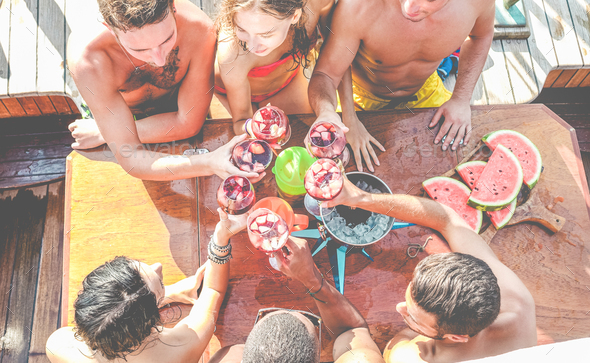 Happy friends having fun cheering with wine in boat party - Stock Photo - Images