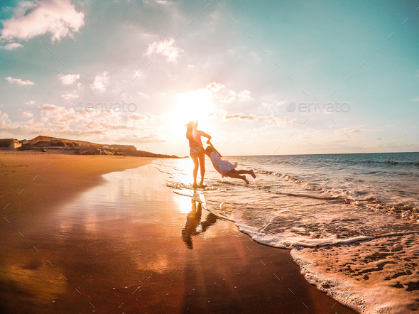 Mother and daughter having fun on tropical beach - Stock Photo - Images