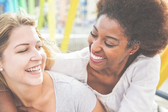 Happy women friends laughing and walking on colorful bridge - Stock Photo - Images