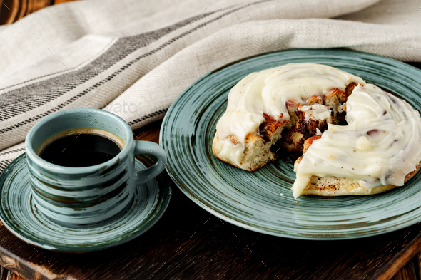 Glazed cinnabon bun in green plate on wooden table Stock Photo by ...