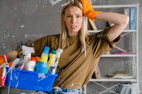 Woman holding basket with cleaning supplies Stock Photo by