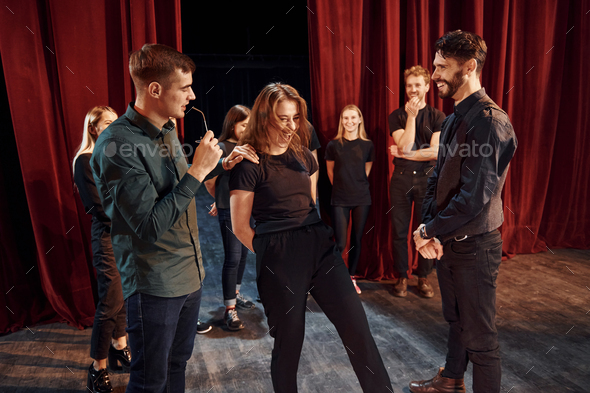 Eye contact practice. Group of actors in dark colored clothes on rehearsal in the theater