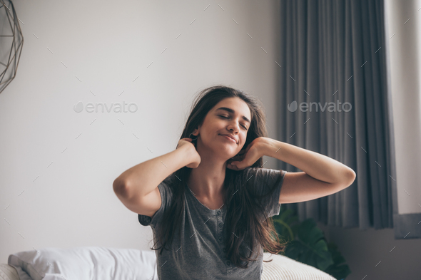 Foto de Well rested woman waking up and stetching do Stock