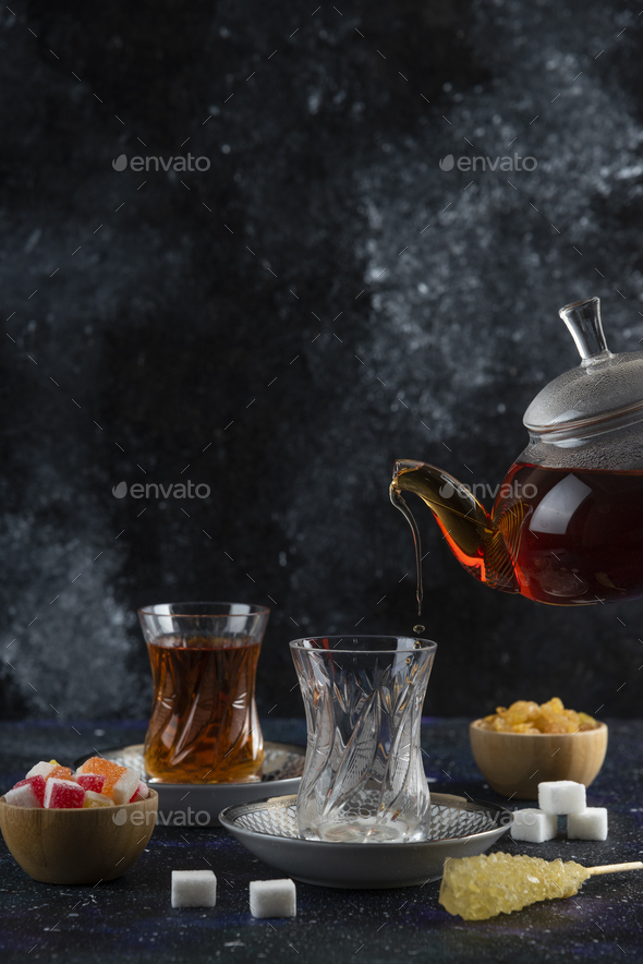 Vertical photo of tea table. Pouring tea to the glass