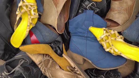 A Big Pile of Discarded Shoes at Dump Site alt