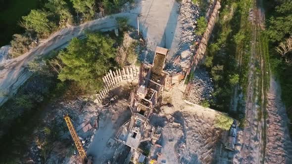 Aerial of truck unloading granite to conveyer alt