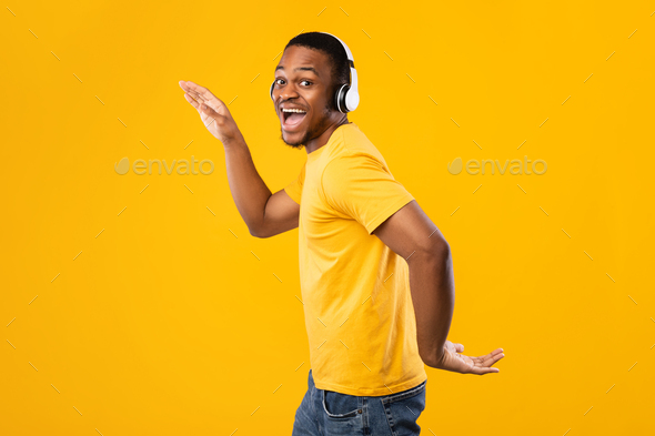 Funny African Guy Dancing Listening Music Wearing Headphones, Yellow Background